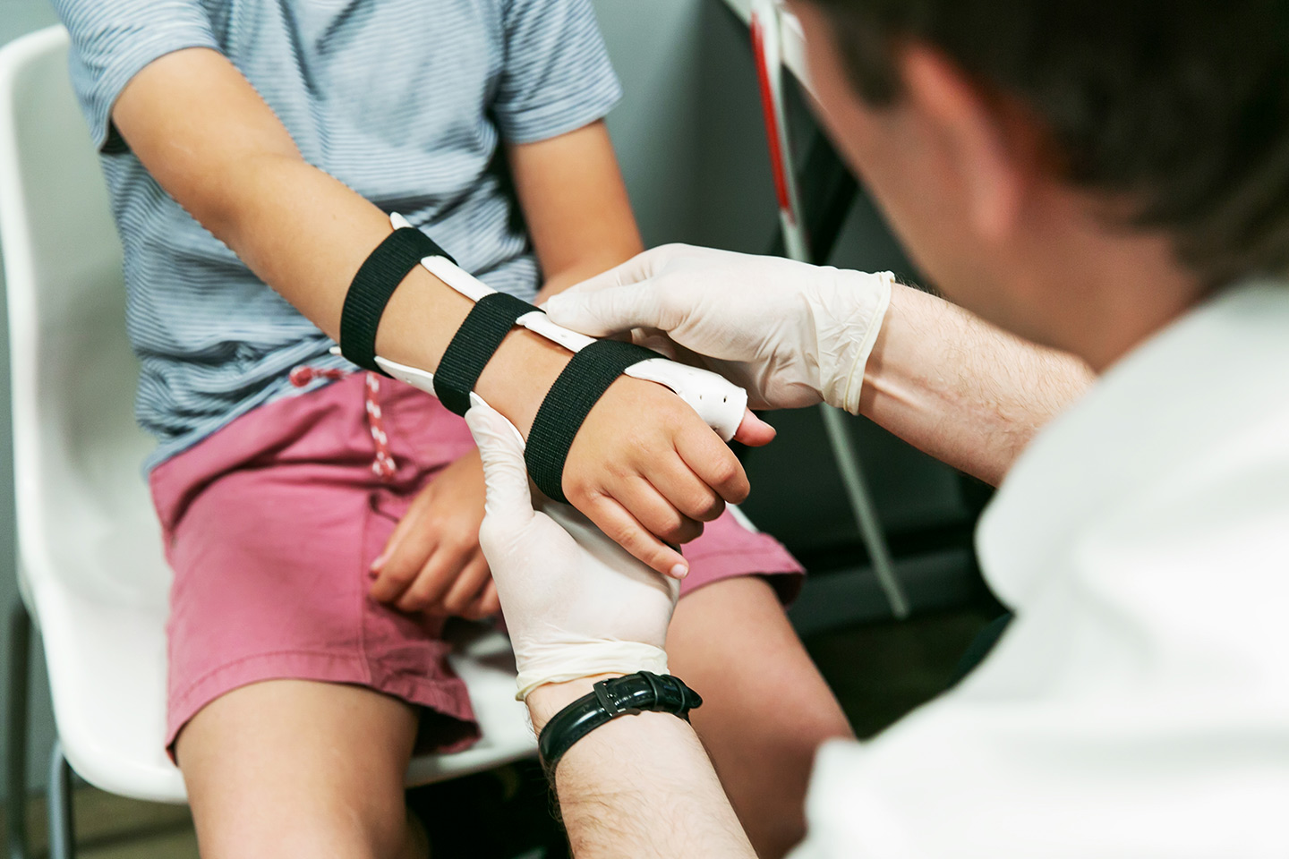 Orthotist fitting a Wrist Hand Orthosis to a young patient.