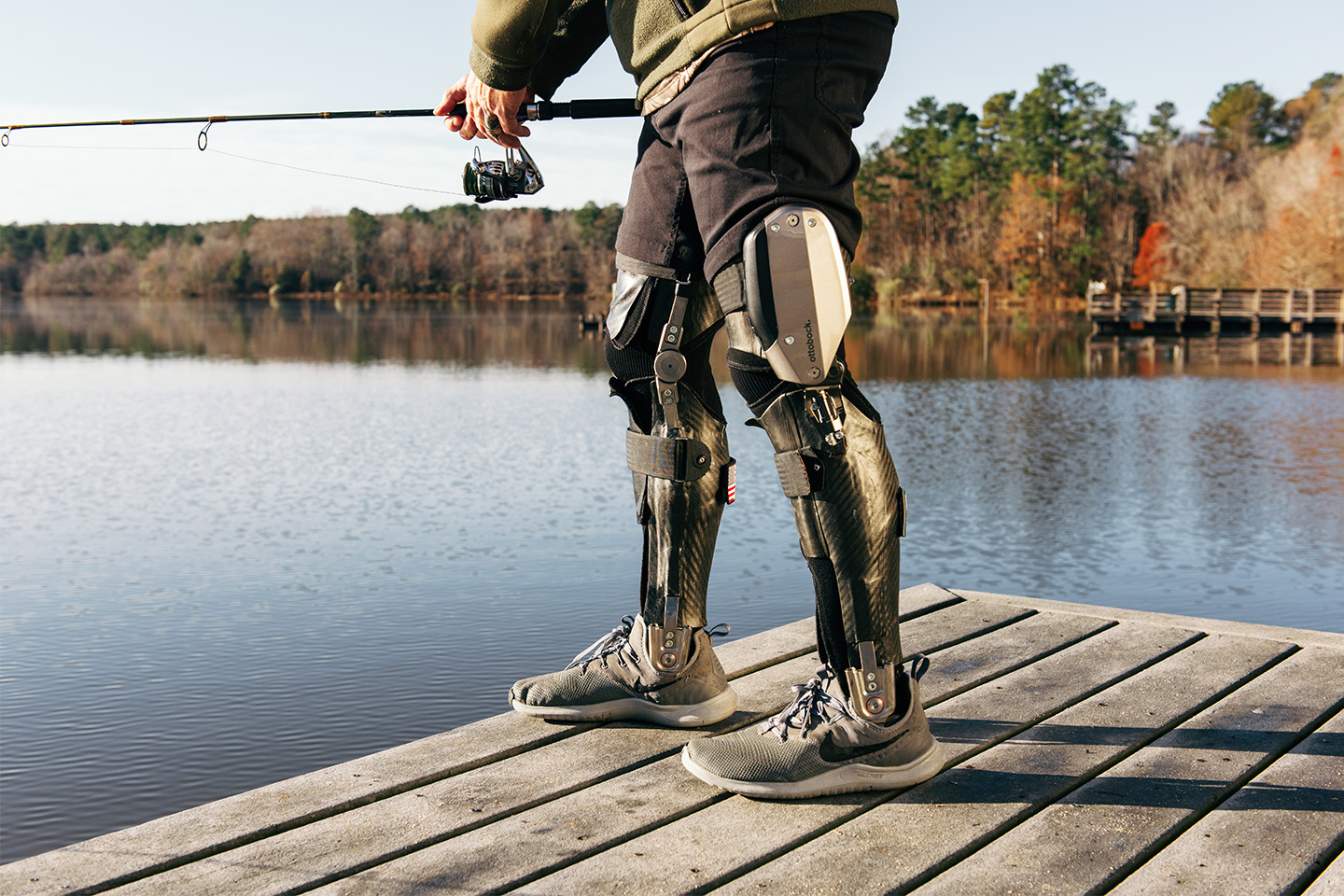 A man wearing dual C-Brace KAFOs whilst fishing from a lake.
