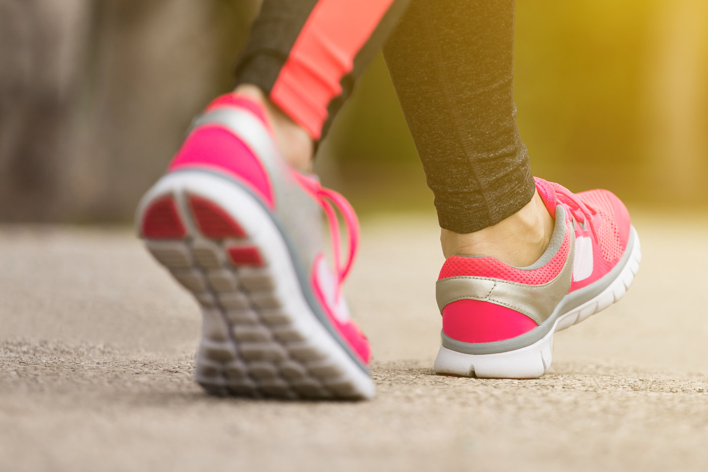 Fitness woman training and jogging in summer park, close up on running shoes in sunlight. Healthy lifestyle and sport concept