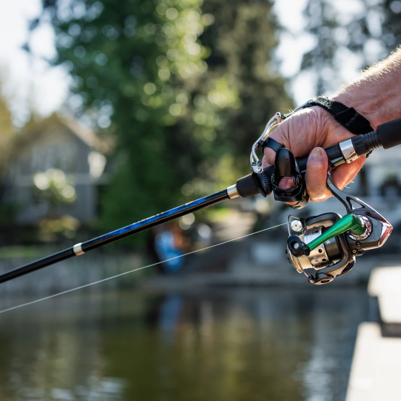 Person holding a fishing rod with body-powered finger and thumb prostheses