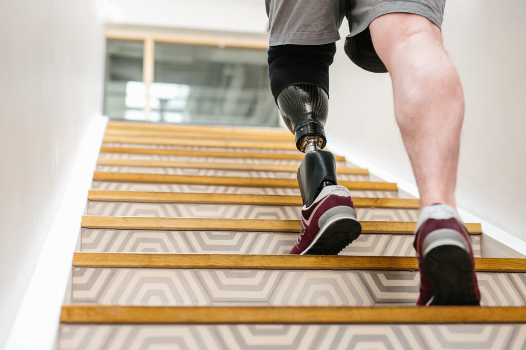 Man walking up stairs with a below knee prosthetic leg